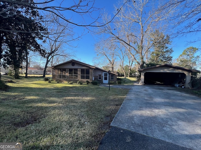 single story home featuring a front yard, an outbuilding, a garage, and a sunroom