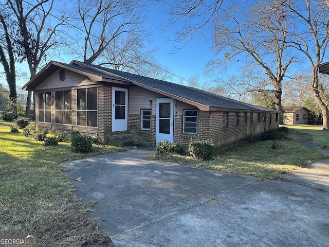 single story home with a sunroom and a front yard