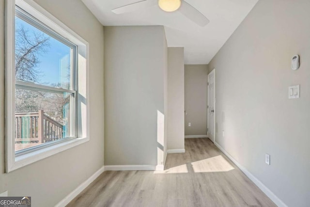 spare room with plenty of natural light, ceiling fan, and light hardwood / wood-style floors