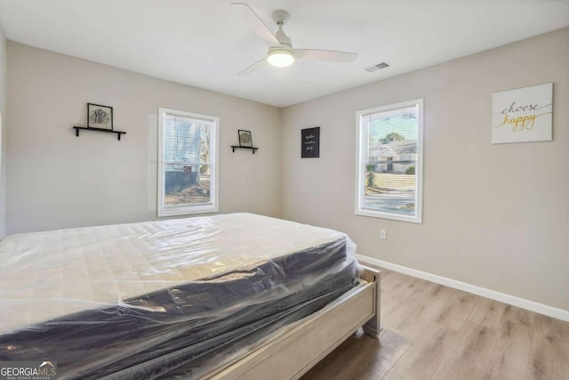 bedroom with light hardwood / wood-style floors and ceiling fan