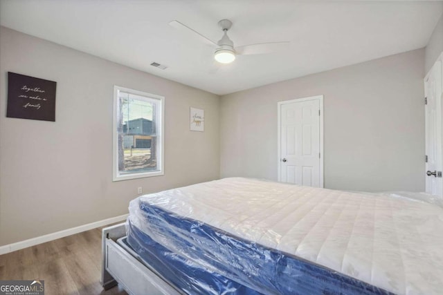 bedroom with ceiling fan and dark hardwood / wood-style flooring