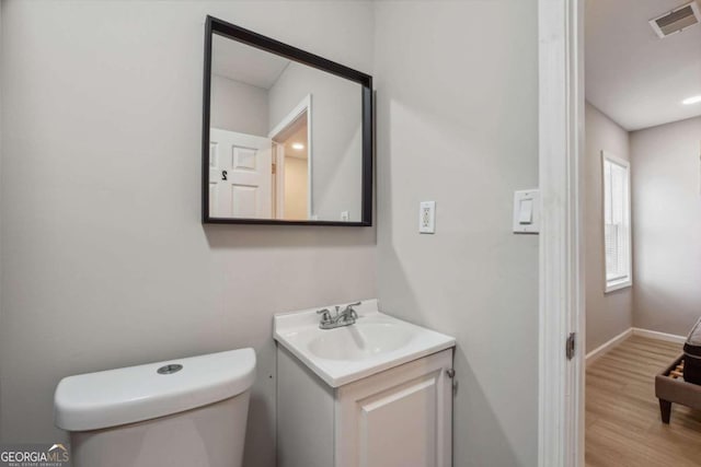 bathroom featuring hardwood / wood-style floors, vanity, and toilet