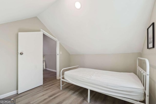 bedroom with light hardwood / wood-style floors and vaulted ceiling