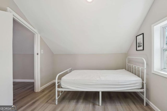 bedroom featuring hardwood / wood-style floors and vaulted ceiling