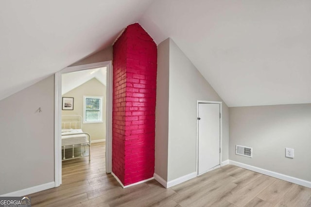 bonus room with light hardwood / wood-style floors and lofted ceiling