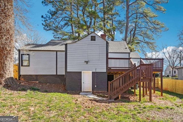 back of house featuring a lawn and a wooden deck