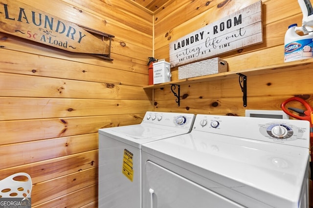 laundry room with separate washer and dryer and wood walls