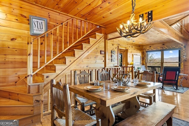 dining room with wooden walls, wooden ceiling, and a notable chandelier