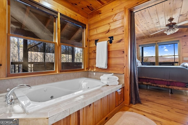 bathroom with a washtub, hardwood / wood-style flooring, ceiling fan, and wooden ceiling