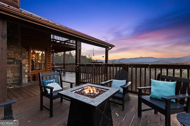 deck at dusk with a mountain view and an outdoor fire pit