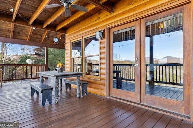 sunroom / solarium featuring beamed ceiling, ceiling fan, and wood ceiling