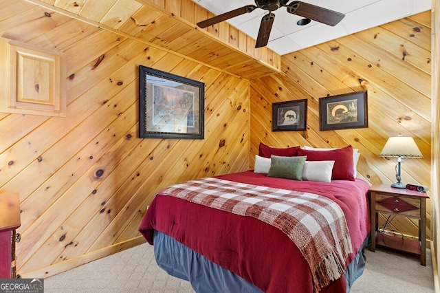 carpeted bedroom with ceiling fan and wooden walls