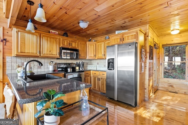 kitchen featuring kitchen peninsula, wood ceiling, stainless steel appliances, sink, and pendant lighting