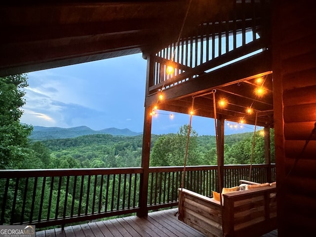 deck at dusk featuring a mountain view