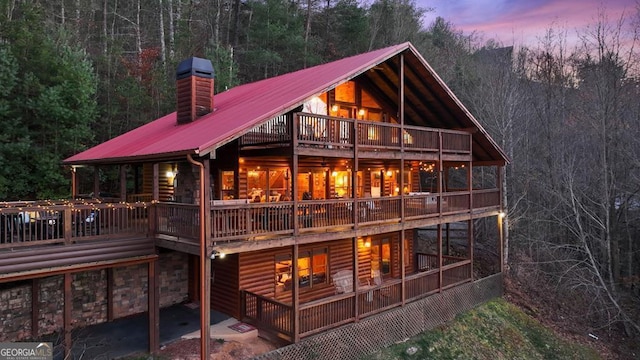 back house at dusk with a balcony