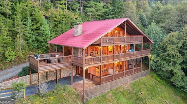 rear view of property featuring a balcony and a patio