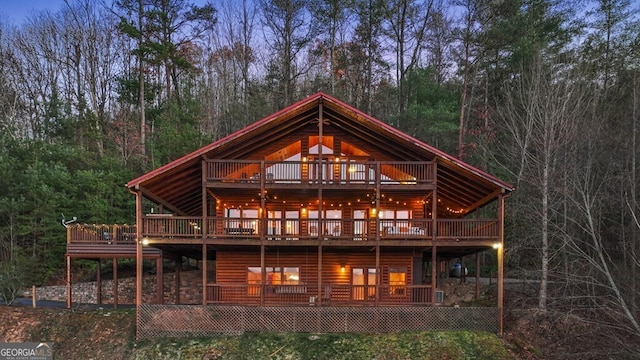 back house at dusk with a wooden deck