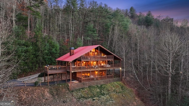 back house at dusk with a deck