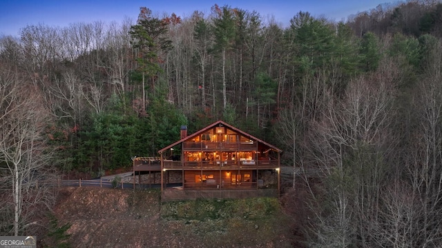 back house at dusk featuring a deck