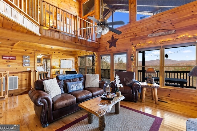 living room featuring ceiling fan, a mountain view, high vaulted ceiling, and light hardwood / wood-style flooring