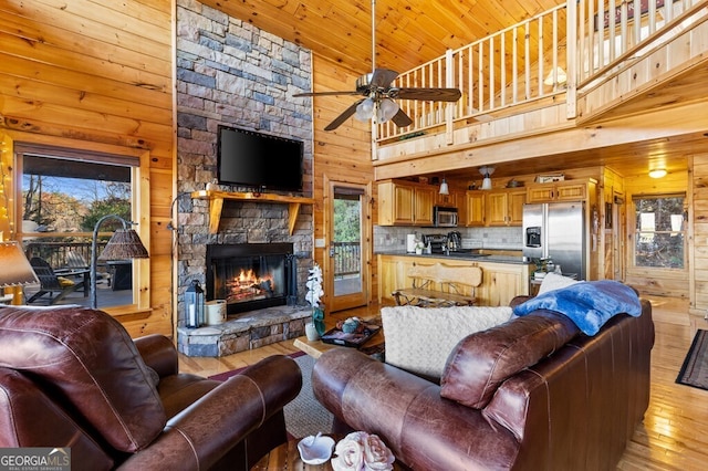 living room with wooden ceiling, high vaulted ceiling, ceiling fan, a fireplace, and light hardwood / wood-style floors