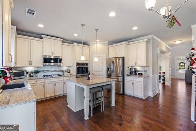 kitchen with sink, decorative light fixtures, a kitchen island, and appliances with stainless steel finishes