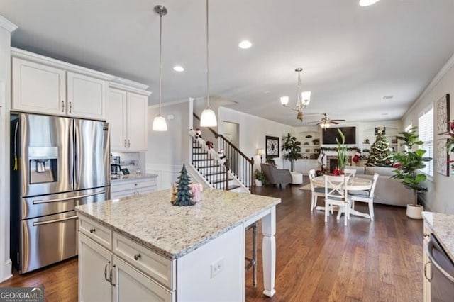 kitchen with a kitchen island, pendant lighting, white cabinets, ceiling fan, and stainless steel appliances