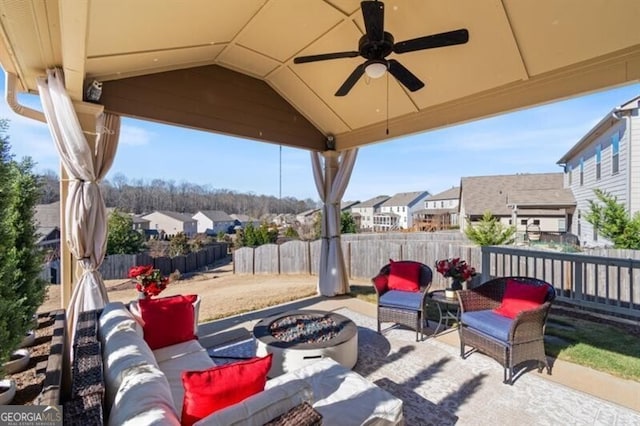 view of patio featuring ceiling fan and an outdoor living space with a fire pit