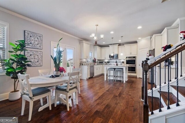 dining space featuring an inviting chandelier, crown molding, and dark hardwood / wood-style floors