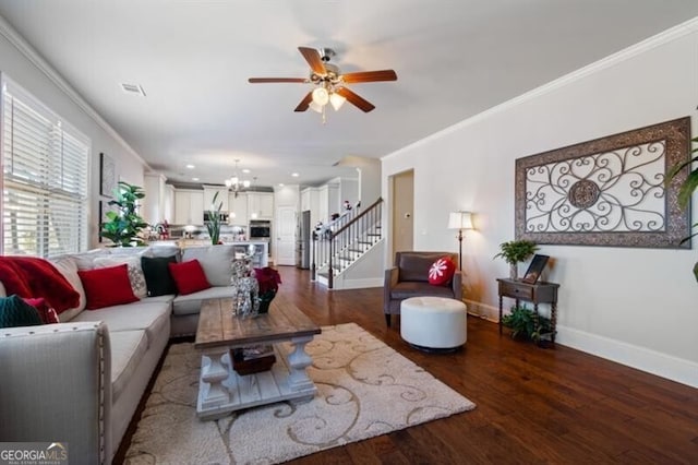 living room with crown molding, ceiling fan with notable chandelier, and hardwood / wood-style floors