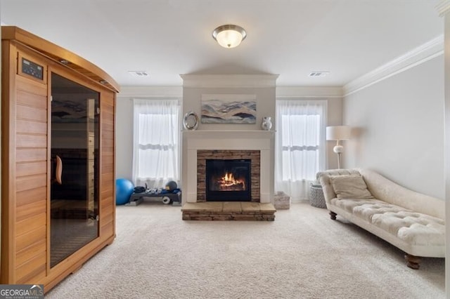 living room with carpet floors, a stone fireplace, plenty of natural light, and ornamental molding