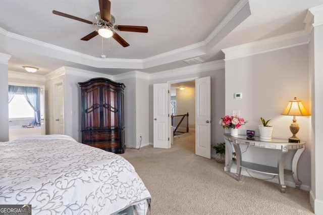 carpeted bedroom featuring crown molding, a tray ceiling, and ceiling fan