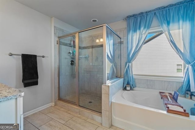 bathroom with vanity, tile patterned flooring, and plus walk in shower