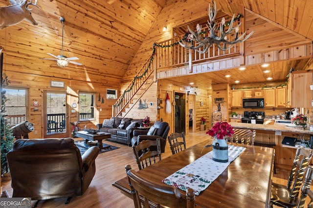 dining room featuring light hardwood / wood-style floors, sink, wooden ceiling, wooden walls, and ceiling fan with notable chandelier