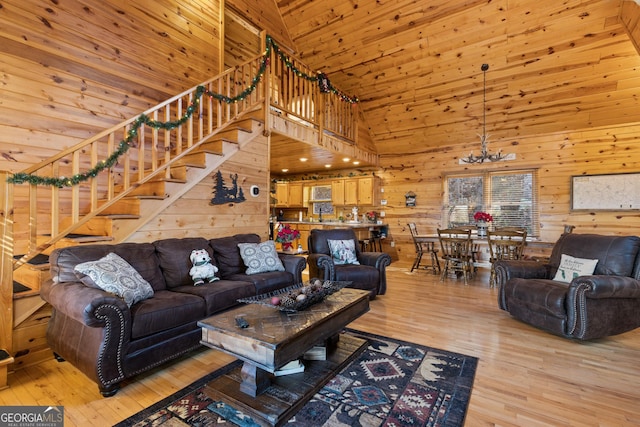 living room featuring light hardwood / wood-style floors, a chandelier, wood walls, and wooden ceiling