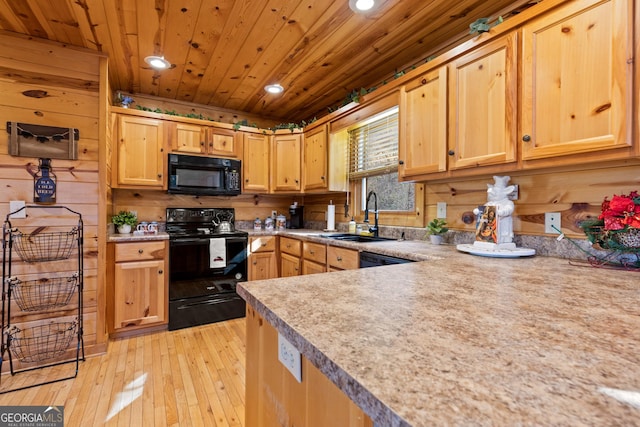 kitchen featuring wooden walls, black appliances, light hardwood / wood-style floors, wood ceiling, and sink