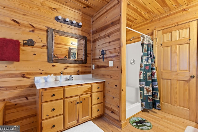 bathroom with vanity, walk in shower, wooden ceiling, and wood walls