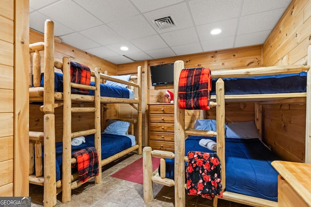 bedroom with wood walls and a drop ceiling