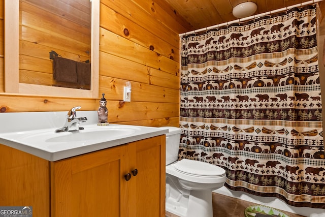 bathroom with vanity, toilet, and wooden walls