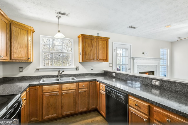 kitchen with sink, hanging light fixtures, dark hardwood / wood-style flooring, a textured ceiling, and black appliances