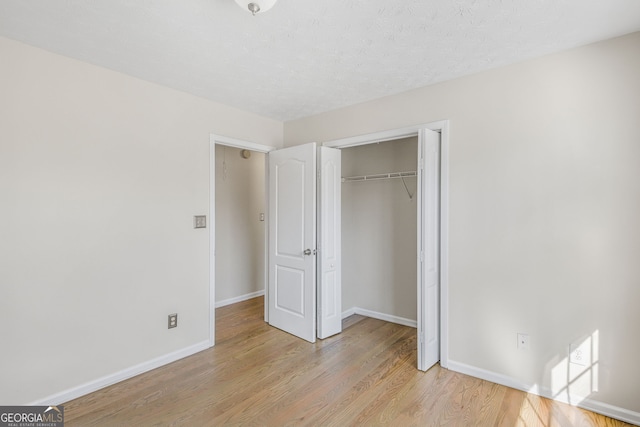 unfurnished bedroom featuring a closet and light hardwood / wood-style flooring