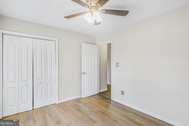 unfurnished bedroom featuring ceiling fan, a closet, and light hardwood / wood-style flooring