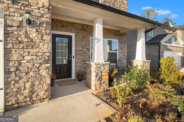 doorway to property with a garage and a porch