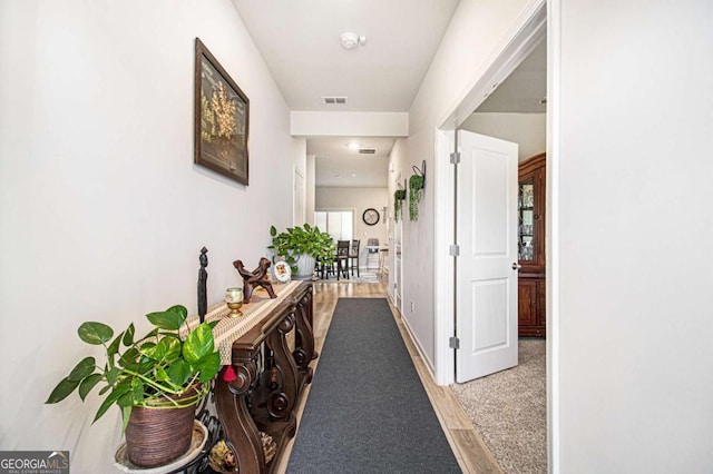 corridor with light hardwood / wood-style flooring