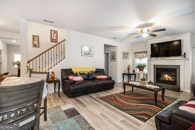 living room with ceiling fan and light wood-type flooring