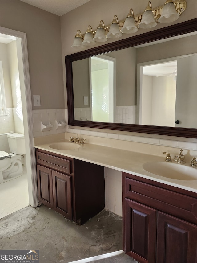 bathroom featuring vanity and tile walls