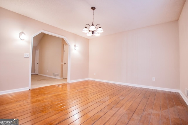 unfurnished room featuring hardwood / wood-style floors and an inviting chandelier