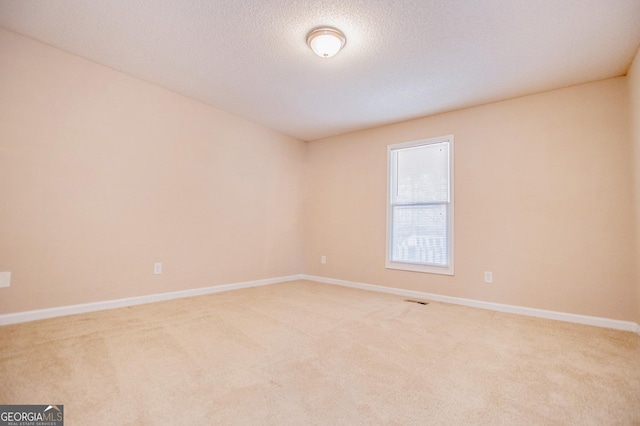 carpeted spare room with a textured ceiling