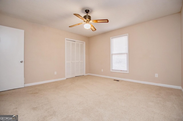 unfurnished bedroom featuring carpet, ceiling fan, and a closet