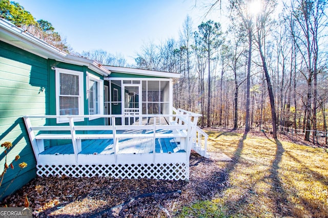 exterior space featuring a wooden deck and a sunroom